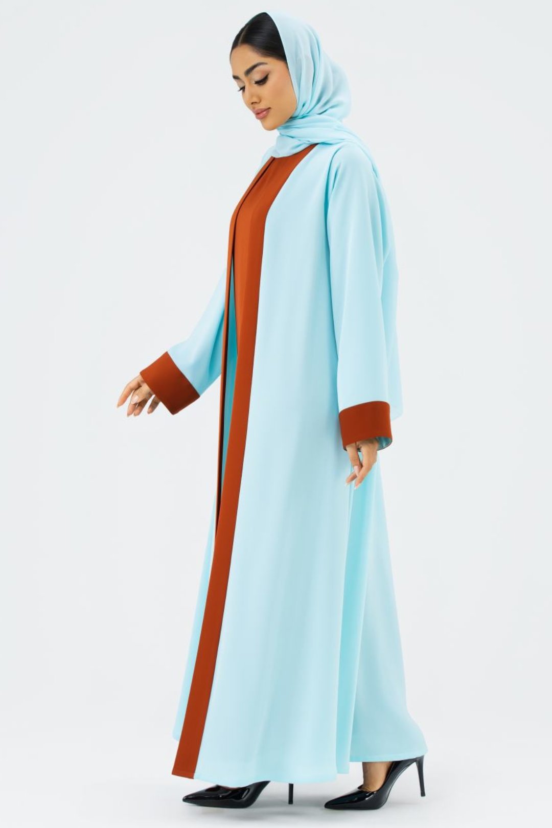 Woman wearing a light blue abaya with brown accents