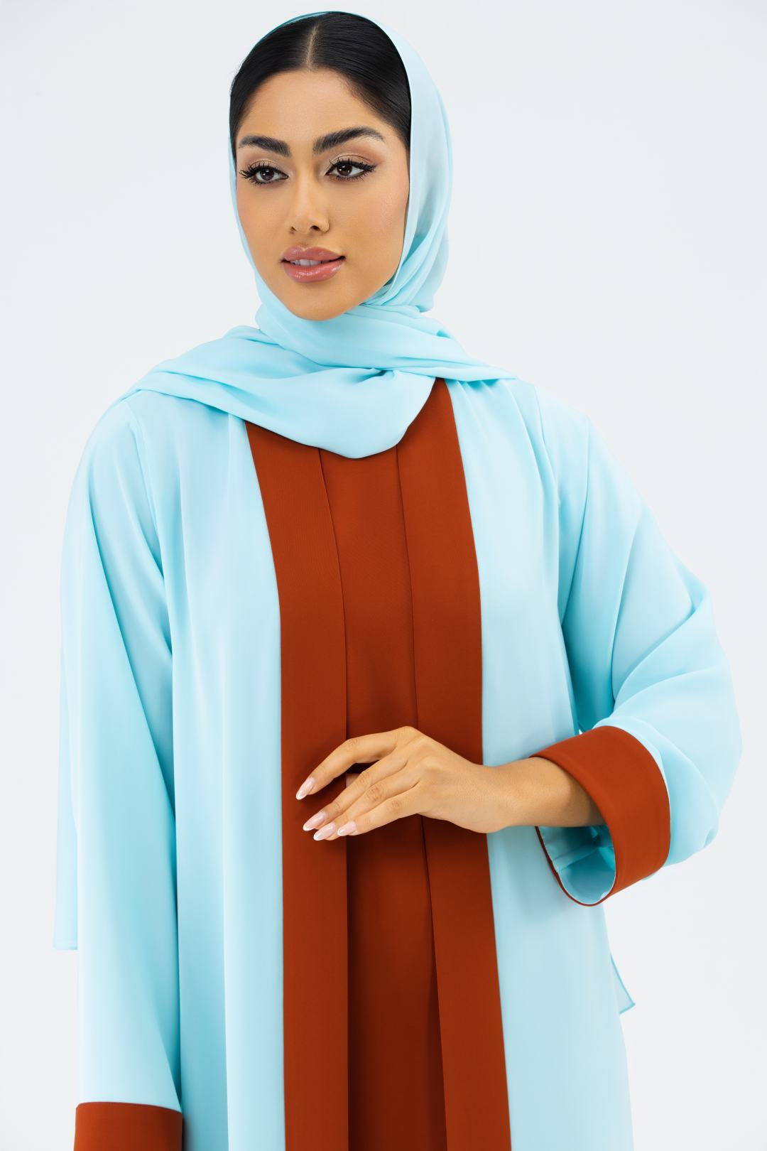 Woman wearing a light blue hijab and brown dress