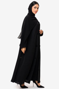 Woman wearing a black abaya on a white background