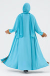 Woman wearing a blue abaya with a brown panel