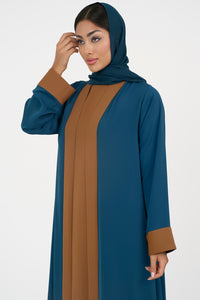 Woman wearing an elegant petrol blue Colored Abaya on a white background