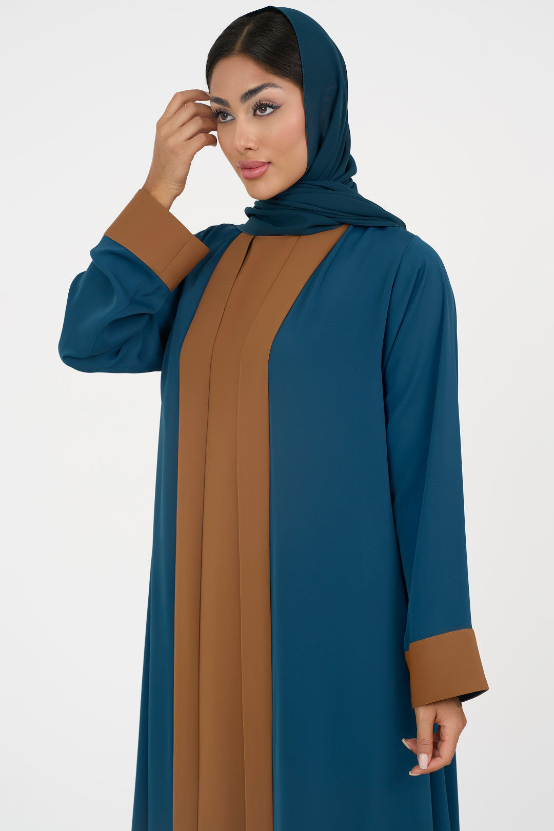 Woman wearing an elegant petrol blue Colored Abaya on a white background