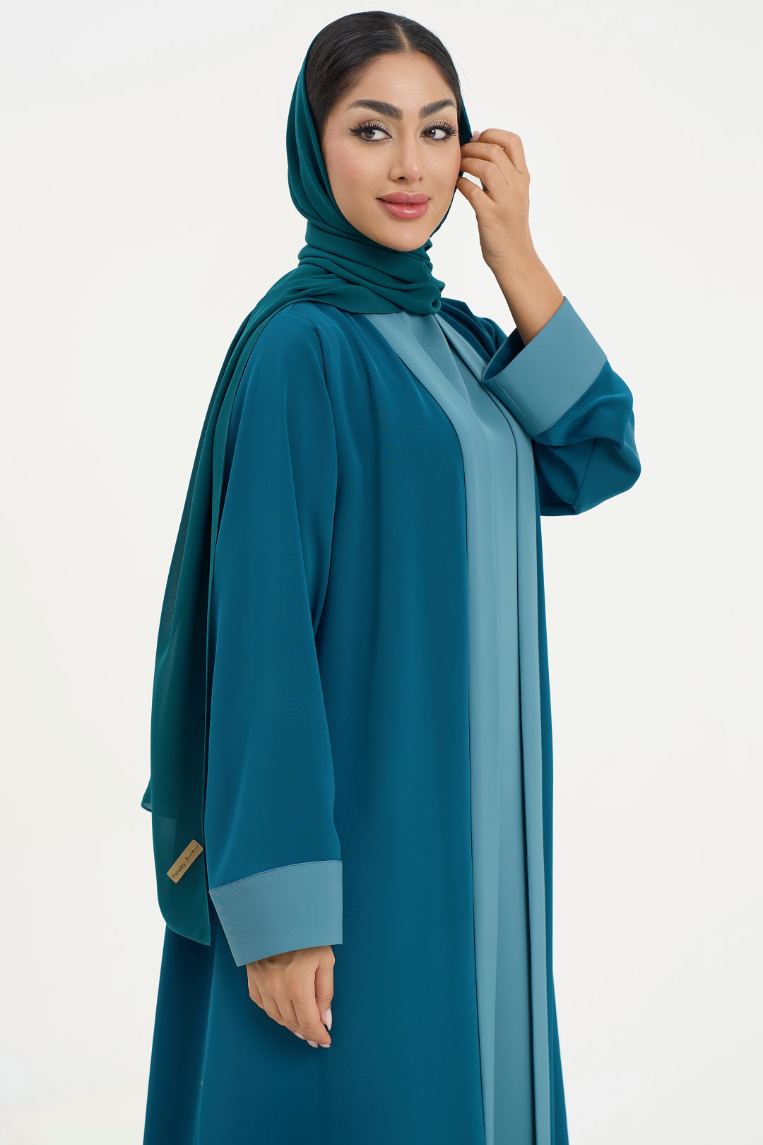 a teal abaya with matching hijab on a white background