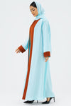 Woman wearing a light blue abaya with brown accents