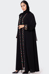 Woman wearing a black abaya with colorful embroidery on a white background