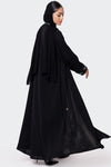Woman wearing a black abaya on a white background