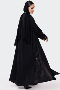 Woman wearing a black abaya on a white background