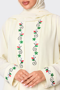 Cream-colored garment with floral embroidery on a plain background