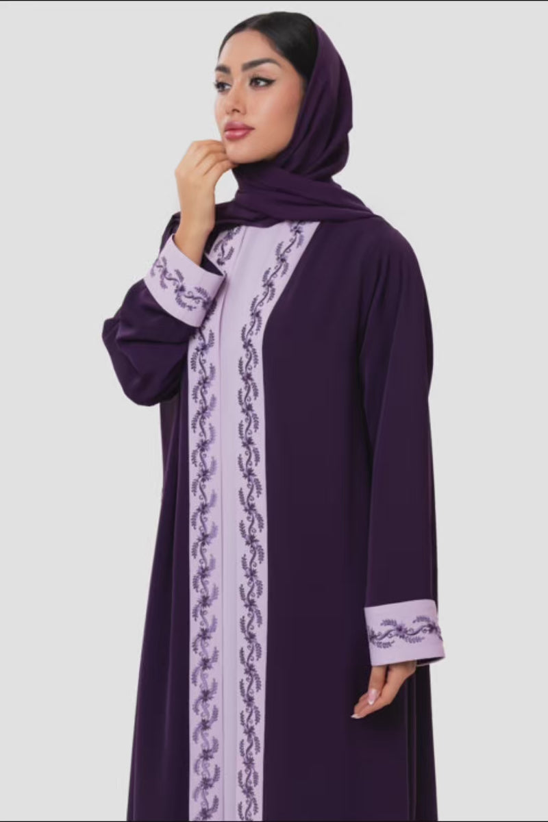Elegant woman in embroidered light and dark purple Fouz Abaya with Austrian crystal detailing, front standing pose.