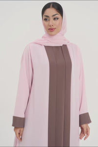 Front view of woman wearing a two-toned baby pink and brown Mayowa abaya