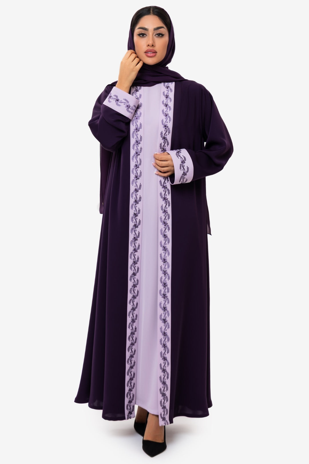 Woman wearing Fouz Abaya in light and dark purple embroidery, standing straight in an elegant fashion look