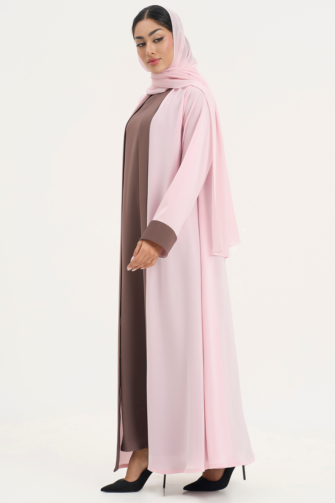 Woman wearing Mayowa abaya in baby pink and brown, standing right side elegant pose