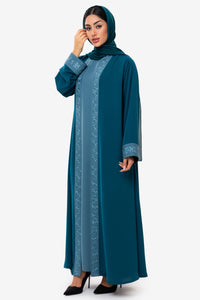 Left-side view of a woman wearing the Mitra Abaya in teal
