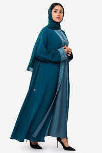 Right-side view of a woman wearing the Mitra Abaya in teal
