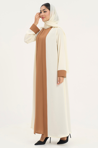 Rana Abaya with off-white and camel tones, standing left and showcasing the design